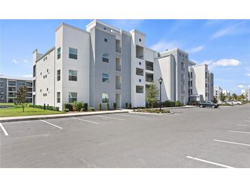 Modern apartment building featuring white and grey exterior with ample parking at 3180 Paradox Circle # 106, Kissimmee, FL 34746