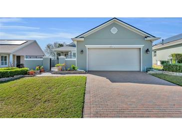 Charming single-story home features brick driveway, manicured lawn, and welcoming facade at 341 Silver Maple Rd, Groveland, FL 34736