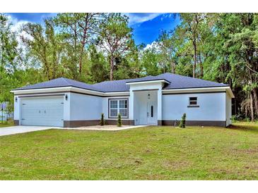 Charming single-story home featuring a two-car garage, neutral paint, and a well-manicured front yard at 12444 Sw 76Th Ln, Dunnellon, FL 34432