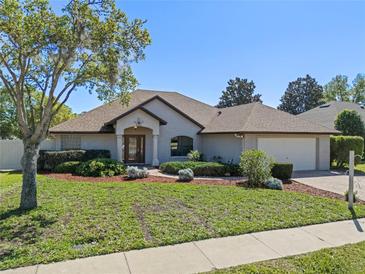 Charming single-story home featuring lush landscaping, a well-manicured lawn, and a welcoming entrance at 4571 Abaco Dr, Tavares, FL 32778