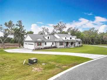 Charming two-story home with a manicured lawn, paved driveway and a neutral color palette at 464 Long & Winding Rd, Groveland, FL 34736