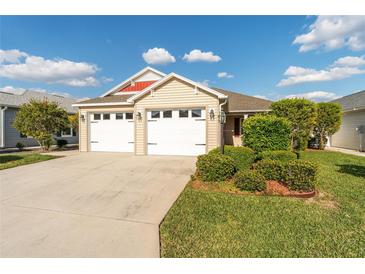 Charming single Gathering home showcasing a well maintained lawn and a two car garage at 5675 Herman Ave, The Villages, FL 32163