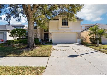 Two-story home with a large tree in the front yard and a two car garage at 8051 Saint James Way, Mount Dora, FL 32757