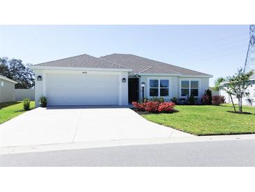 Charming single-story home with a well-manicured lawn and attached two-car garage at 1435 Jeremy Cir, The Villages, FL 34762