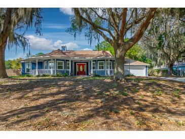 Charming home with a sprawling yard and inviting red front door at 7549 Frog Log Ln, Leesburg, FL 34748