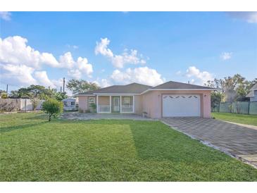 Charming single-story home boasts a well-manicured lawn and a quaint front porch, plus a two car garage and driveway at 910 Rich Dr, Mount Dora, FL 32757