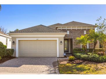 Beautiful single-story home featuring stone accents, a two-car garage and a well-manicured lawn at 1023 Timbervale Trl, Clermont, FL 34715