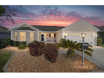 Charming single-story home featuring a well-maintained lawn and inviting curb appeal with a lovely sky at 1417 Forest Acres Dr, The Villages, FL 32162