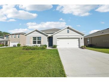 Charming single-story home featuring a well-manicured lawn and a two-car garage on a sunny day at 2916 Canary Ln, Tavares, FL 32778