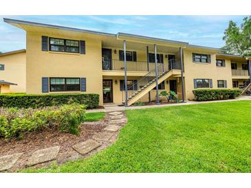 Inviting exterior of a two-story home featuring a well-manicured lawn and charming walkway at 110 N Tremain St # 205, Mount Dora, FL 32757