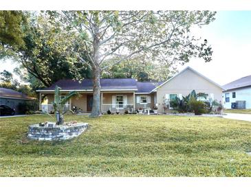 Charming single-story home featuring a well-manicured lawn and a cozy porch with decorative accents at 11312 Haskell Dr, Clermont, FL 34711