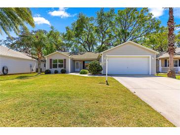 Charming single-story home with a well-maintained lawn and attached two car garage at 2488 Ansley Path, The Villages, FL 32162