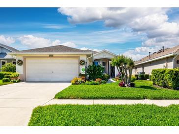 Charming single-story home boasts a well-manicured lawn and vibrant landscaping at 27121 Greenfly Orchid Ln, Leesburg, FL 34748