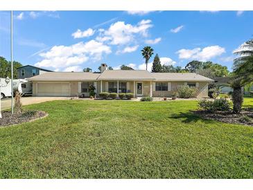 Charming single-story home with a well-manicured lawn and inviting front porch at 28416 Tammi Dr, Tavares, FL 32778