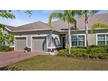 Inviting home exterior featuring a well-manicured lawn, brick driveway, and a two-car garage at 3512 Belland Cir # B, Clermont, FL 34711