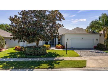 Charming single-story home with a well-manicured lawn, lush landscaping, and a two-car garage at 3728 Mulberry Grove Loop, Leesburg, FL 34748