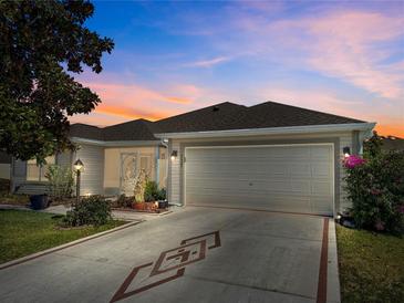 Charming single Gathering home featuring a large driveway, a two-car garage, and manicured landscaping at 737 Caldwell Ct, The Villages, FL 32162