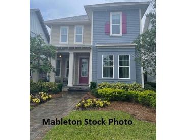 Charming two-story home with manicured lawn and lush landscaping enhancing curb appeal at 9905 Gobat Aly, Orlando, FL 32827