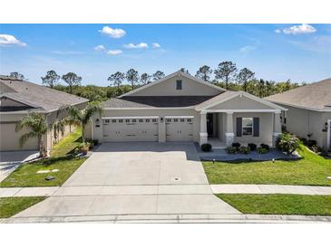 Beautifully landscaped single-story home featuring a three-car garage and inviting front porch at 197 Pineywoods St, St Cloud, FL 34772