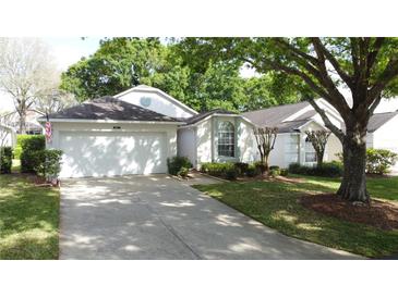 Charming single-story home with a two-car garage, manicured lawn, and mature trees at 3827 Westerham Dr, Clermont, FL 34711