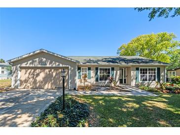 Well-maintained home with green shutters, a paved walkway and manicured landscaping at 25642 Oak Aly, Leesburg, FL 34748