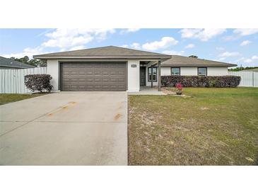 Well-maintained single-story home featuring a two-car garage and a neatly landscaped front yard at 12370 Se 100Th Ct, Belleview, FL 34420