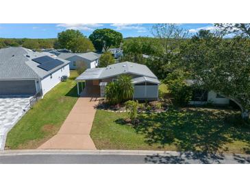 Charming home with a well-kept lawn and long driveway at 1541 Doral Cir, Lady Lake, FL 32159