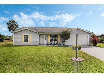 Charming home with a well-manicured lawn, light-grey siding, and inviting curb appeal at 25818 Belle Alliance, Leesburg, FL 34748