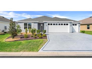 Charming single-story home with a two-car garage, landscaped yard, and inviting curb appeal at 2775 Navy Hill Cir, The Villages, FL 32163