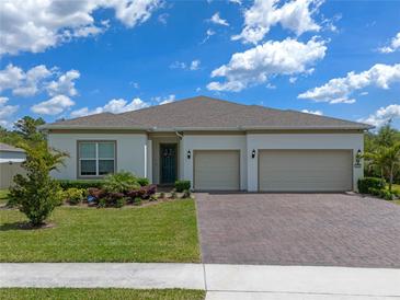 Well maintained single Gathering home featuring brick paved driveway, lush landscaping and a three car garage at 4131 Sunset Preserve Blvd, Orlando, FL 32820