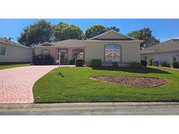 Charming single-story home featuring a well-manicured lawn and inviting curb appeal with pink driveway at 5008 Sawgrass Lake Cir, Leesburg, FL 34748