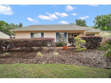 Charming single-story home featuring manicured landscaping, warm exterior colors, and classic shutters at 97 Hillside Dr, Eustis, FL 32726
