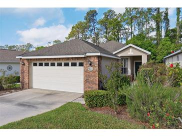 Charming single-Gathering home with brick facade, two-car garage, and landscaped front yard at 1022 Saint Ives Ct, Mount Dora, FL 32757