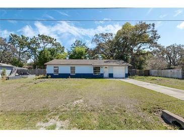 Charming single-story home with two-tone paint, a well-manicured lawn, and mature trees at 11987 Se 95Th Ter, Belleview, FL 34420