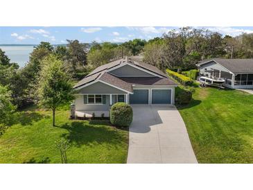 Beautiful single-Gathering home with a well-manicured lawn, two-car garage, and a view of the lake at 137 E Palmetto Ave, Howey In The Hills, FL 34737