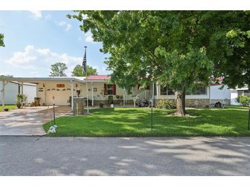 Charming home featuring a well-maintained lawn, mature trees, and a convenient carport at 1901 Brookside Dr, Mount Dora, FL 32757