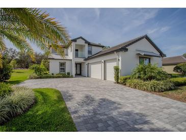 Beautiful two-story home showcasing a well-manicured lawn, palm trees, and a spacious three-car garage with a stone driveway at 25962 High Hampton Cir, Sorrento, FL 32776