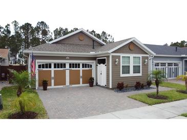 Charming home featuring a brick-paved driveway, a two-car garage and tidy landscaping at 368 Alcove Dr, Groveland, FL 34736