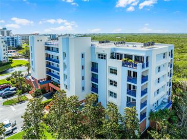 Beautiful condominium building with blue accents and balconies overlooking lush greenery and blue skies at 5300 S Atlantic Ave # 16-202, New Smyrna Beach, FL 32169
