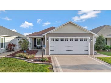 Charming single Gathering home featuring a two-car garage, inviting front patio, and lovely landscaping at 5702 Grimes Ct, The Villages, FL 32163
