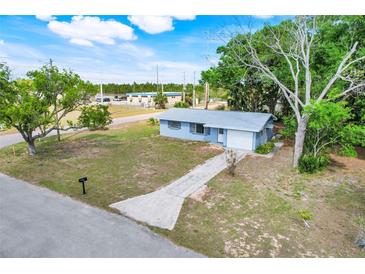 Inviting single-story home with a well-maintained lawn, mature trees, and attached garage at 1109 Hampton St, Clermont, FL 34711