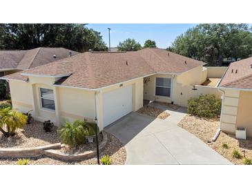 Charming home features a well-maintained lawn, lovely landscaping, and a two-car garage at 1208 Santa Cruz Dr, The Villages, FL 32162