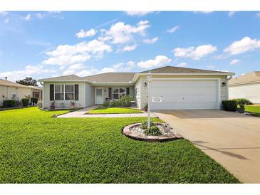 Well-maintained one-story home with a lush lawn and a two-car garage at 1733 Oakville Pl, The Villages, FL 32162