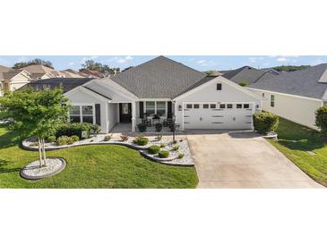 Well-maintained home with charming landscaping, manicured lawn, and welcoming curb appeal at 1940 Dempsey Ln, The Villages, FL 32163