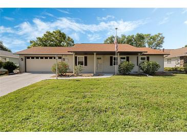 Charming single-story home with a well-maintained lawn, a two car garage, and appealing curb appeal at 26535 Deuce Ct, Leesburg, FL 34748