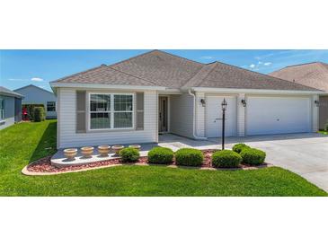 Beautiful home featuring manicured landscaping and a well-maintained lawn at 2992 Hicks Pl, The Villages, FL 32163