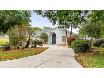 Charming single-story home featuring a well-manicured lawn and a curved driveway leading to the front entrance at 11024 Windchime Cir, Clermont, FL 34711