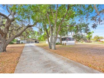 Charming one-story home with a long driveway, lush trees, and well-maintained lawn at 16724 Highland Ave, Montverde, FL 34756