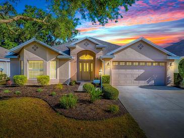 Charming home featuring manicured lawn, mature trees, neutral paint, and an attached two car garage at 1741 Pennecamp Dr, The Villages, FL 32162