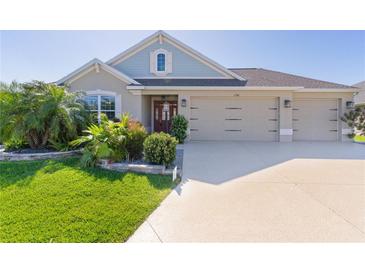 Charming single-story home showcasing a well-manicured lawn and a three-car garage, inviting curb appeal at 1796 Zientara Loop, The Villages, FL 32163